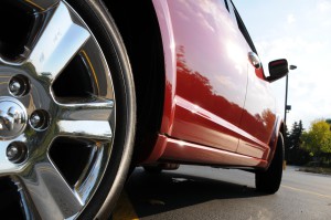 The passenger side and close-up of the rear wheel on a red Dodge Journey.